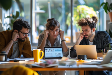 Three exhausted course leaders sit at a table with laptops and analytics data, searching for clarity about Learning Friction in Moodle.